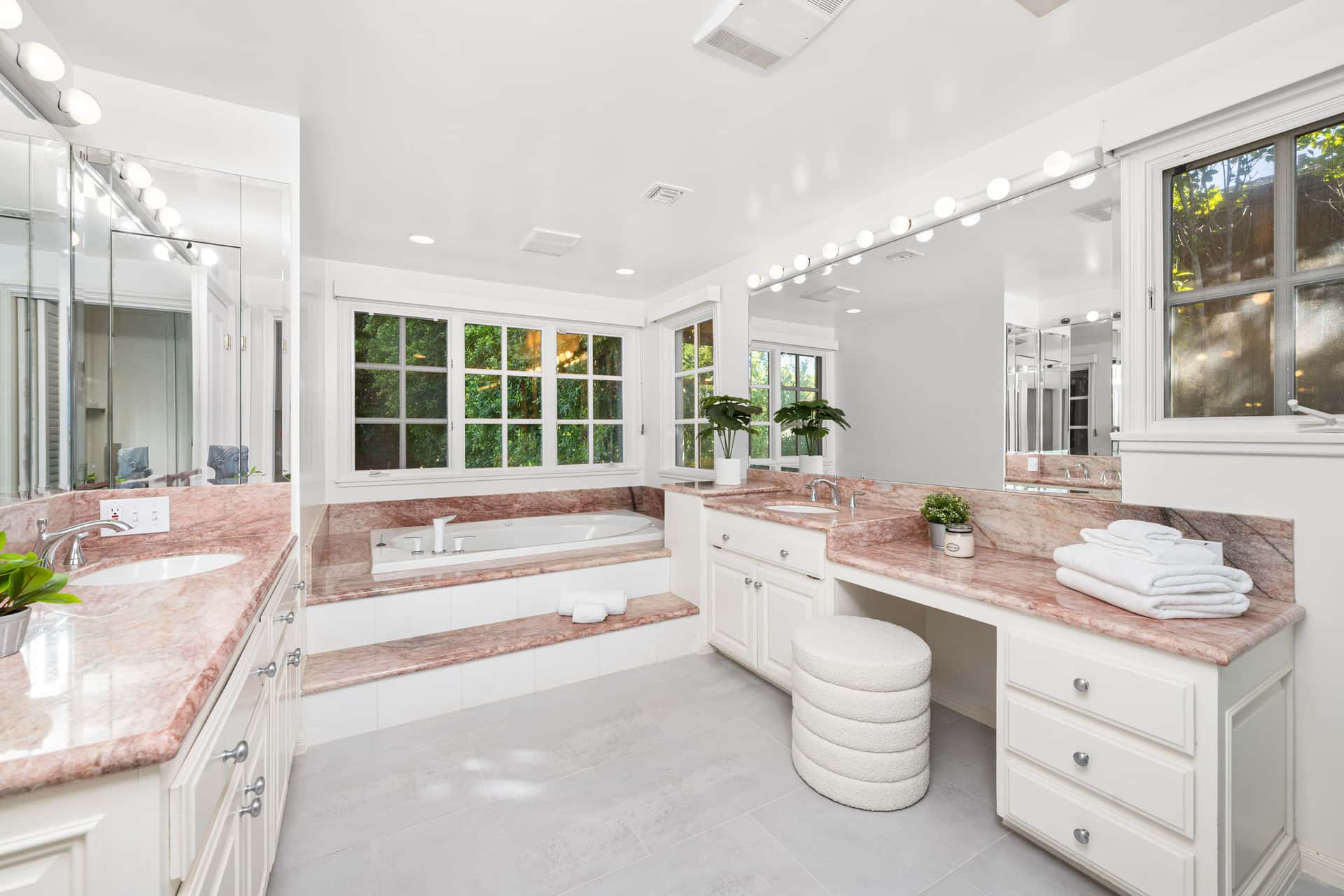 Spacious Elegant Bathroom with Marble Countertops and Garden Views